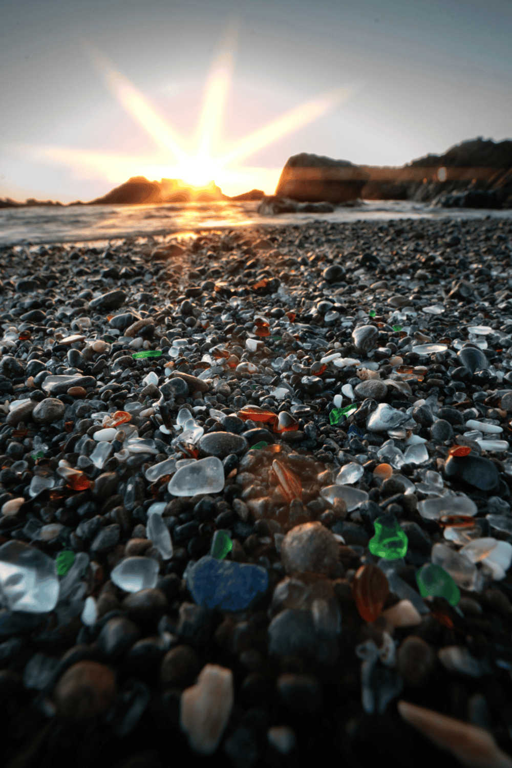 1. Beach with colorful glass and pebbles at sunset, coastal scenery, QuestForDirections.