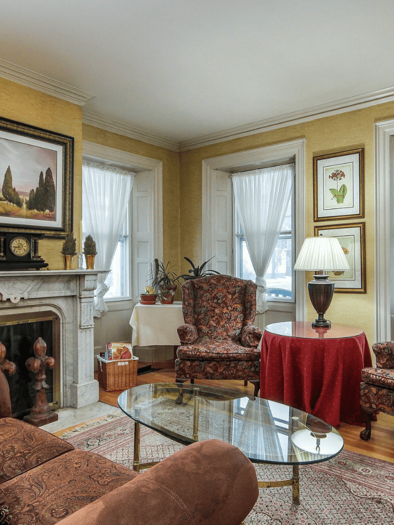 Cozy vintage living room with antique furniture, fireplace, and warm decor accents.