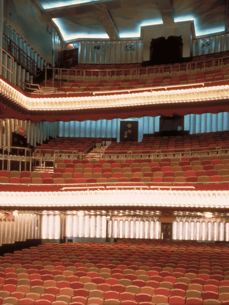 Grand theater interior with tiered seating and ambient lighting | QuestForDirections.