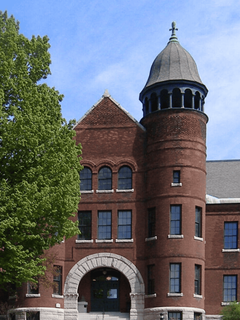 Sophisticated brick castle-like building with tower and arched entrance, part of QuestForDirections location.