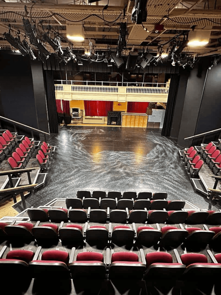 Theater stage with seating, lighting, and sound equipment, ideal for performances at QuestForDirections.