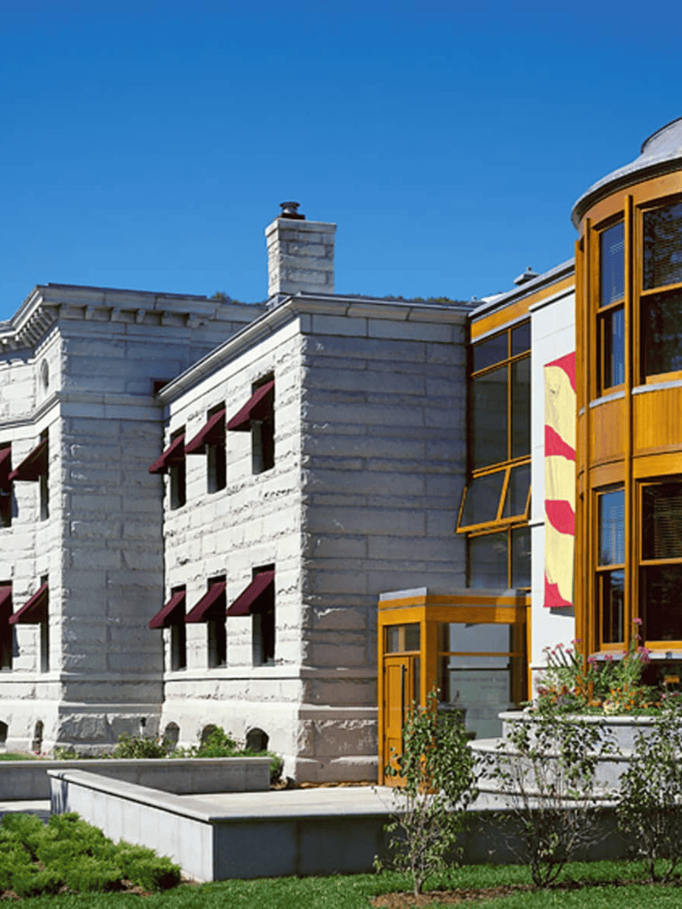 Charming modern house exterior with stone walls, large windows, and colorful accents.