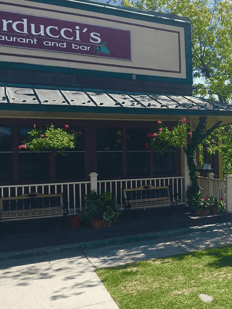 Cozy restaurant front with hanging flower baskets and outdoor seating, inviting dining experience.
