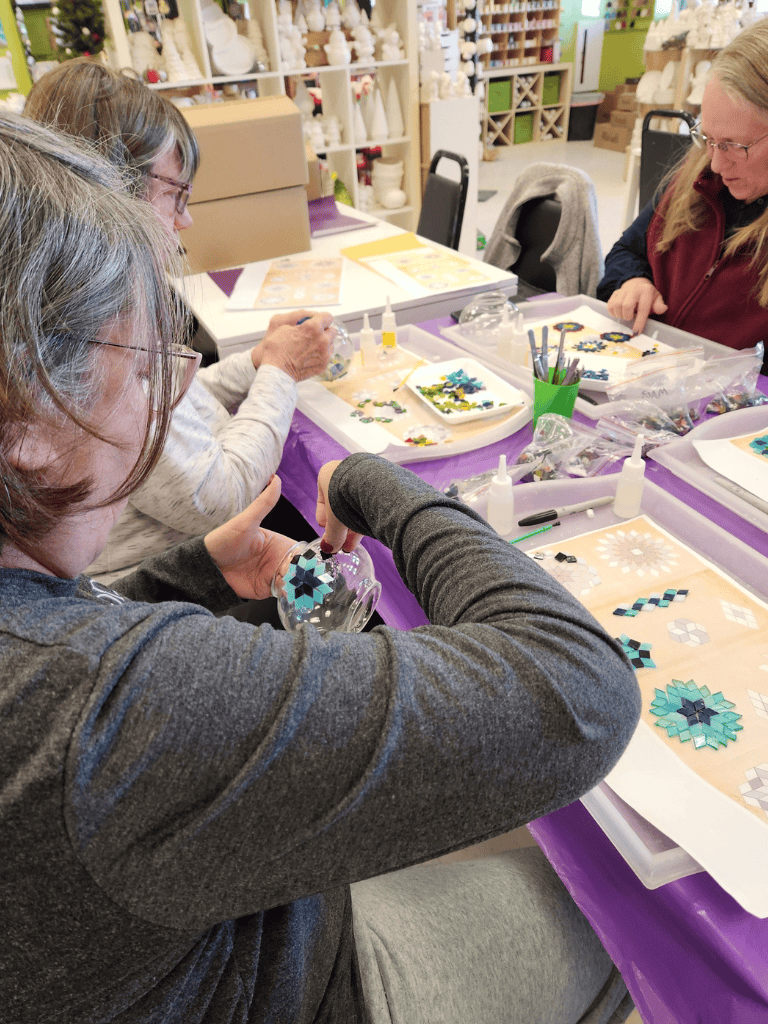 Colorful mosaic glass ornaments creation with women crafting in a DIY workshop.