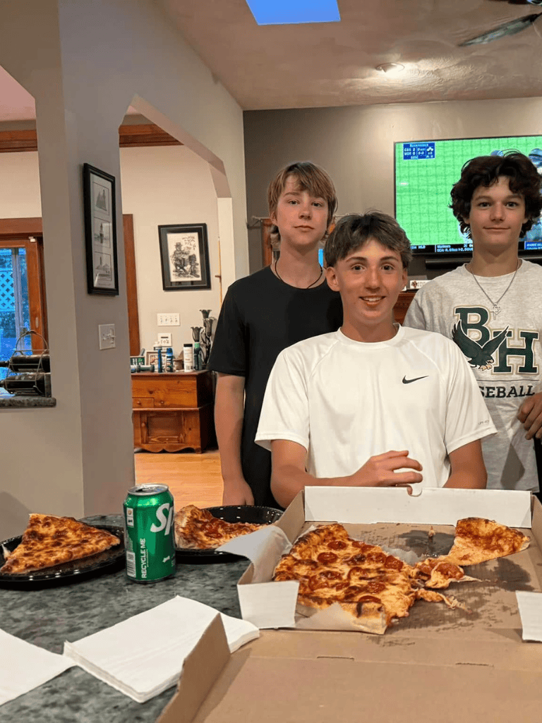 Kids enjoying pizza night at home, celebrating with friends and a soda.