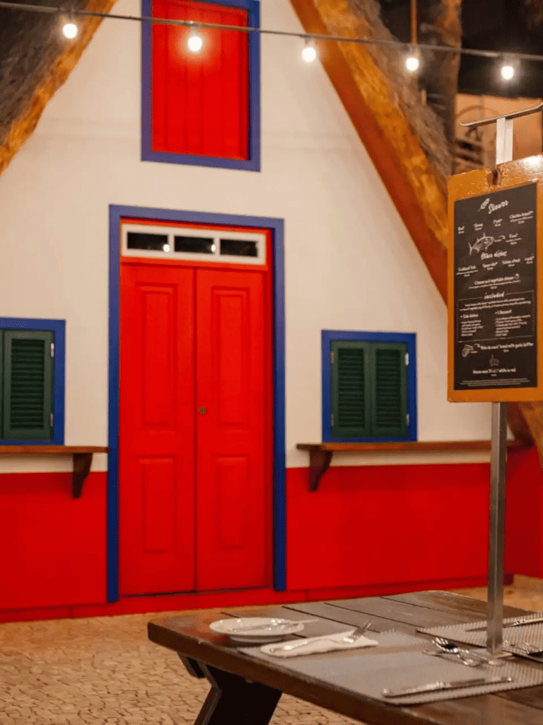 Colorful restaurant interior with red, blue, and green accents and cozy lighting for dining.