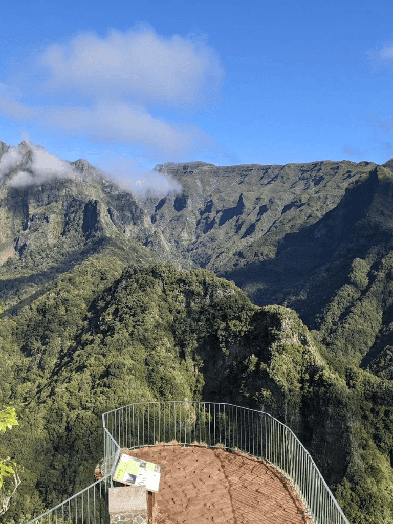 Breathtaking mountain landscape with observation deck overlooking lush green valleys and rugged peaks.