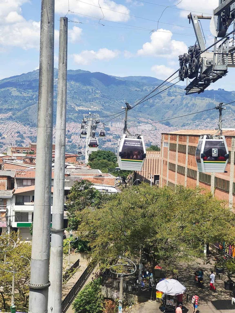 Cable car transportation over urban landscape with mountains in the background.