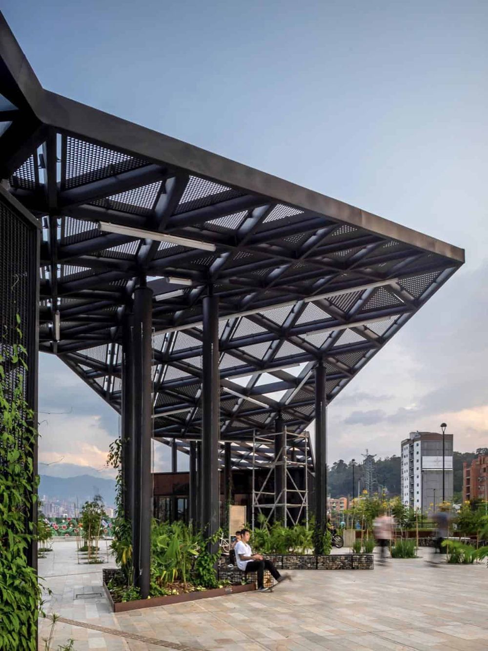 Modern urban park with innovative architectural structure and seating areas, perfect for relaxation and community gatherings.