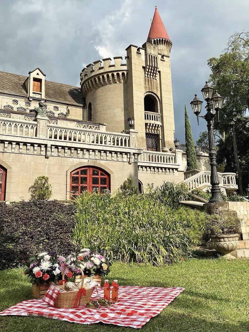 Fairy tale castle with picnic setup, elegant architecture, and lush garden, perfect for romantic getaways or family adventures.