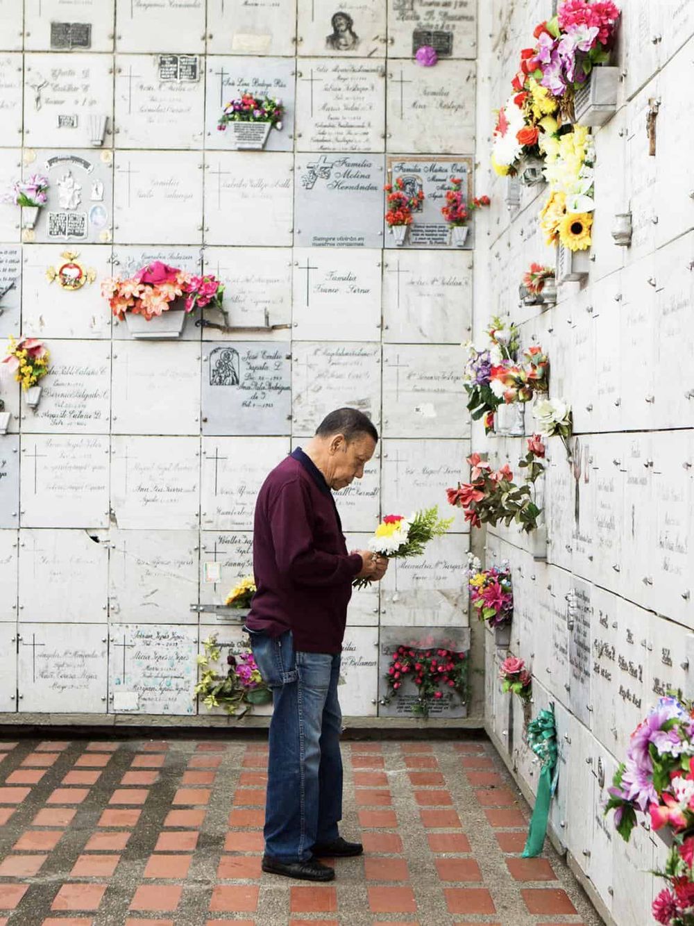 Memorial wall with flowers, honoring loved ones at a cemetery or mausoleum.