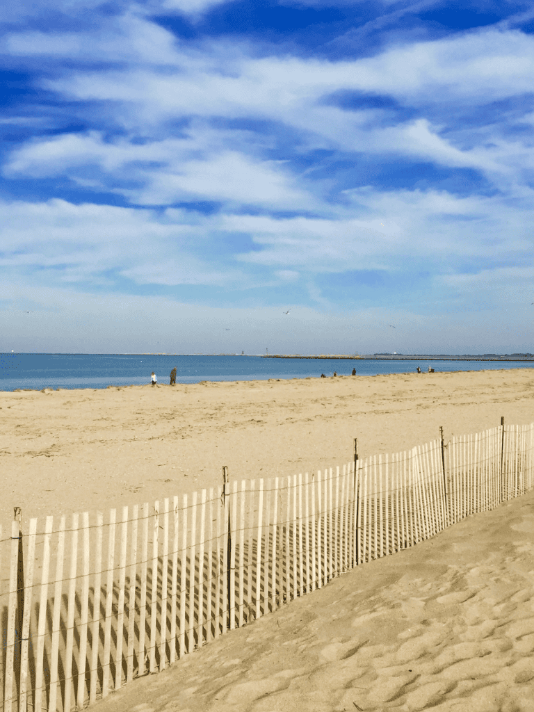 Serene beach scene with sky, ocean, and sand dunes for travel destinations SEO optimization.