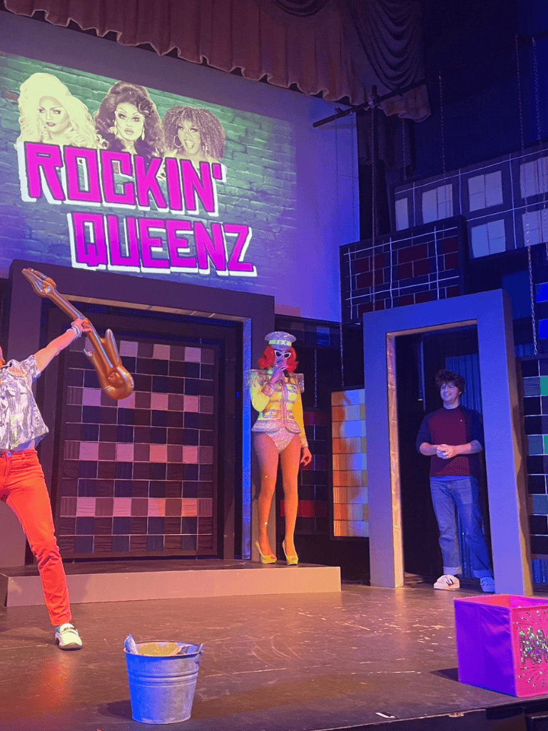 Rockin' queens drag show performance at QuestForDirections event in a theater setting.