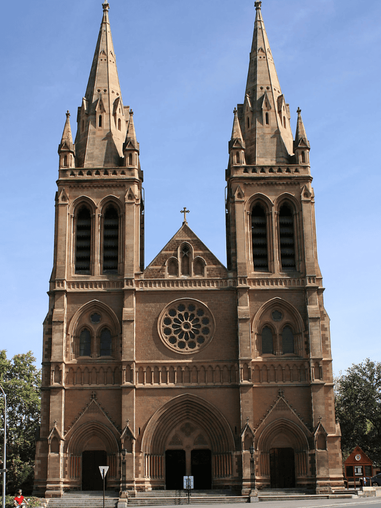 Majestic gothic church with twin spires and rose window, architectural photography, religious landmark.