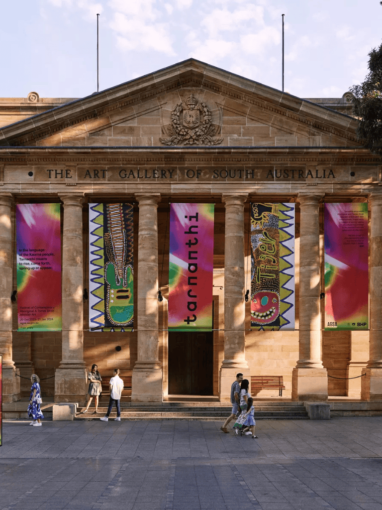 Colorful banners hanging outside the Art Gallery of South Australia showcasing contemporary art exhibitions.