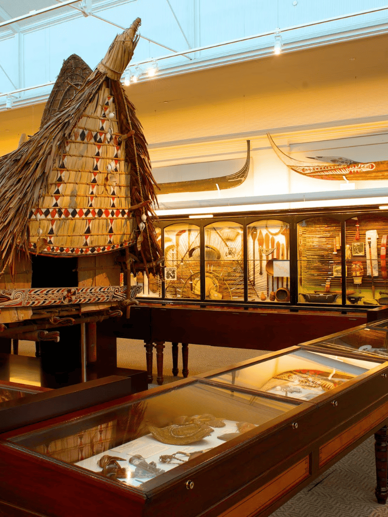 Ancient Polynesian canoe and artifacts display at Quest for Directions museum, showcasing traditional navigation tools.