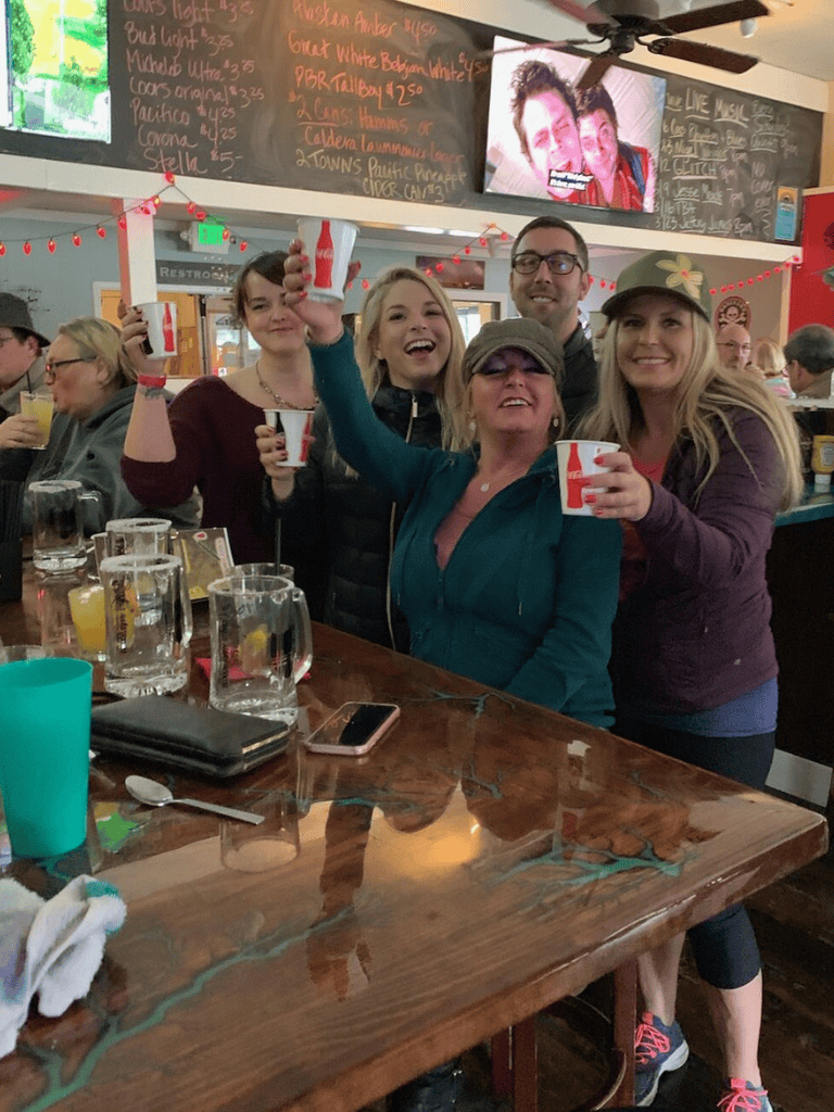 Cheerful group celebrating with drinks at a cozy bar or restaurant, creating a lively and friendly atmosphere.