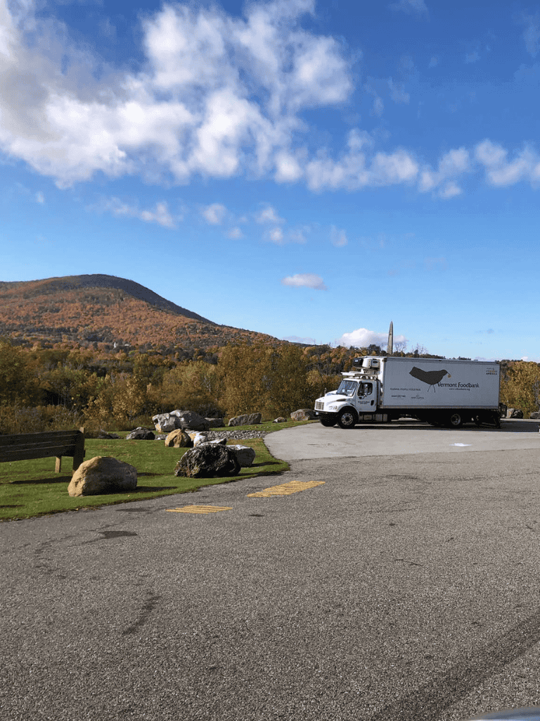 Vermont Foodbank truck parked with mountain and autumn trees in background for food assistance programs.