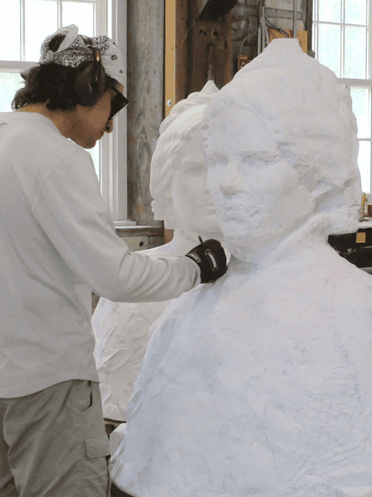Intricate snow sculpture of a woman with detailed facial features and headwear at QuestForDirections.
