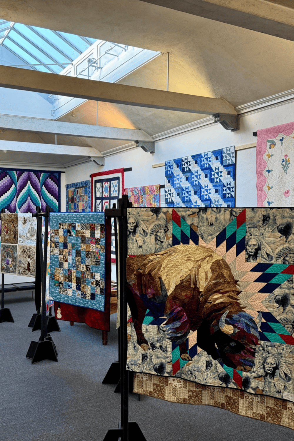 Colorful quilt art display at Quest For Directions exhibit showcasing unique textile craftsmanship.