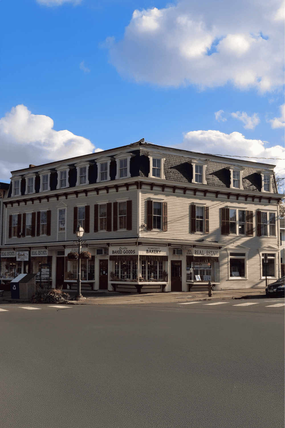 1. Vintage building with bakery and real estate shops in small town, scenic sky view.
