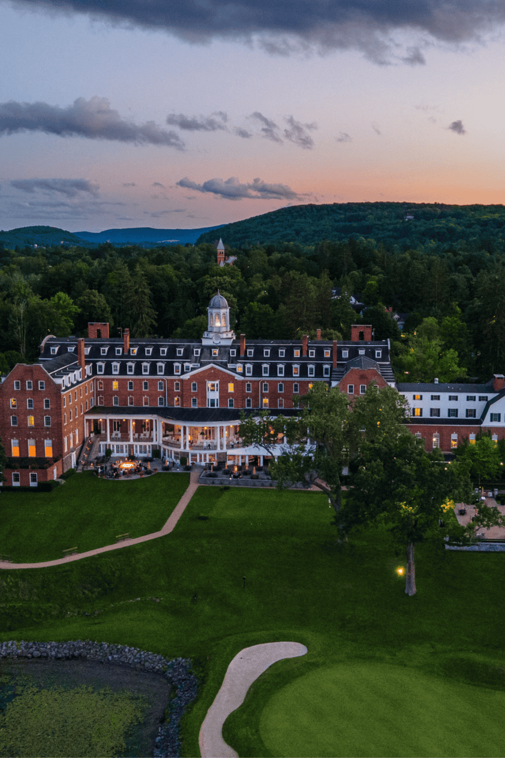 Historic hotel with mountain views and lush greenery in a scenic location.