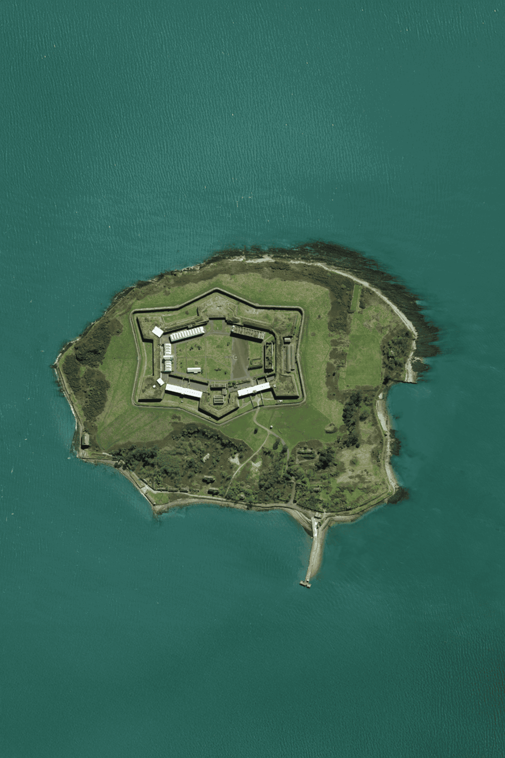 Aerial view of a historic fortress on a small island surrounded by water, highlighting travel and navigation services.