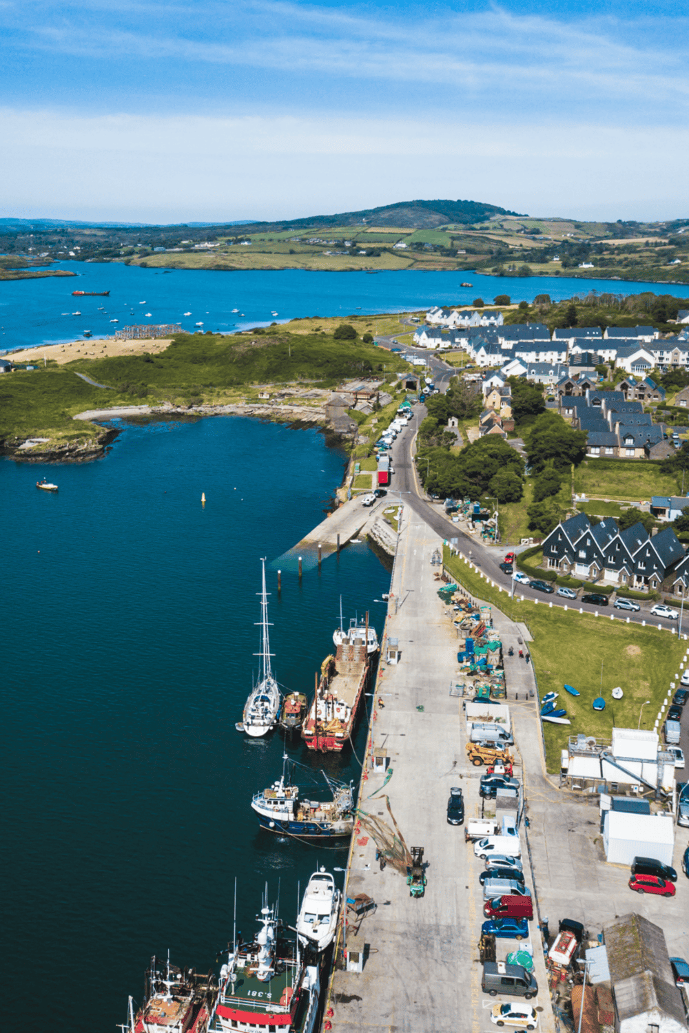 Harbor and coastal town with boats, harbor facilities, and scenic landscape views.