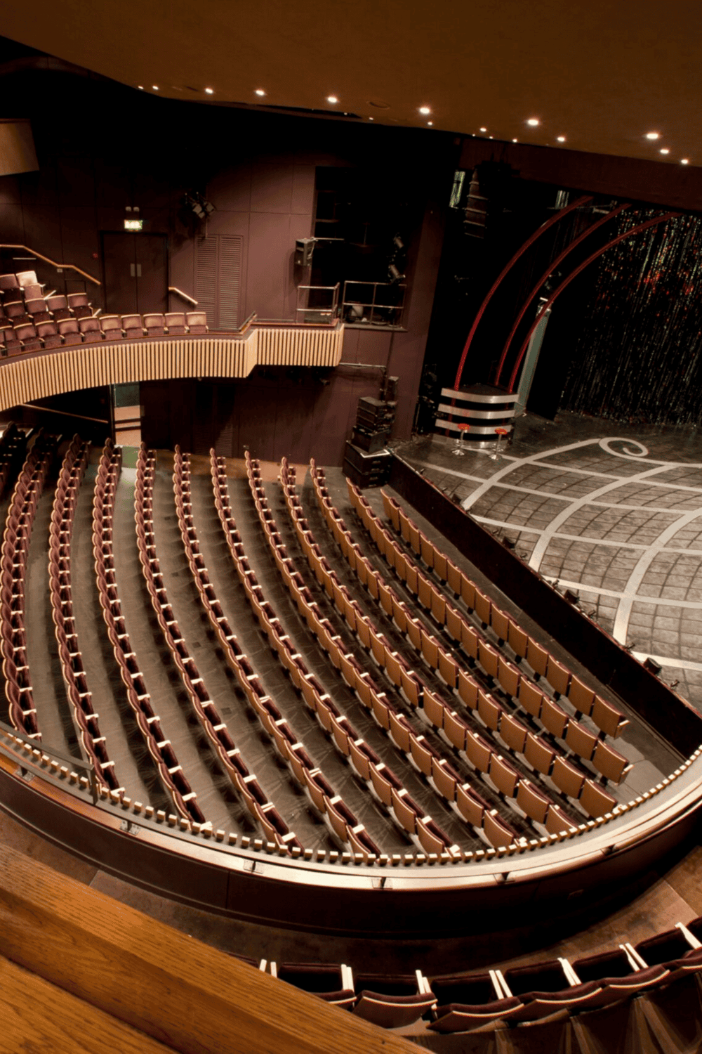 Empty theater auditorium with stage, seating, and lighting for live performances, part of Quest for Directions venue.