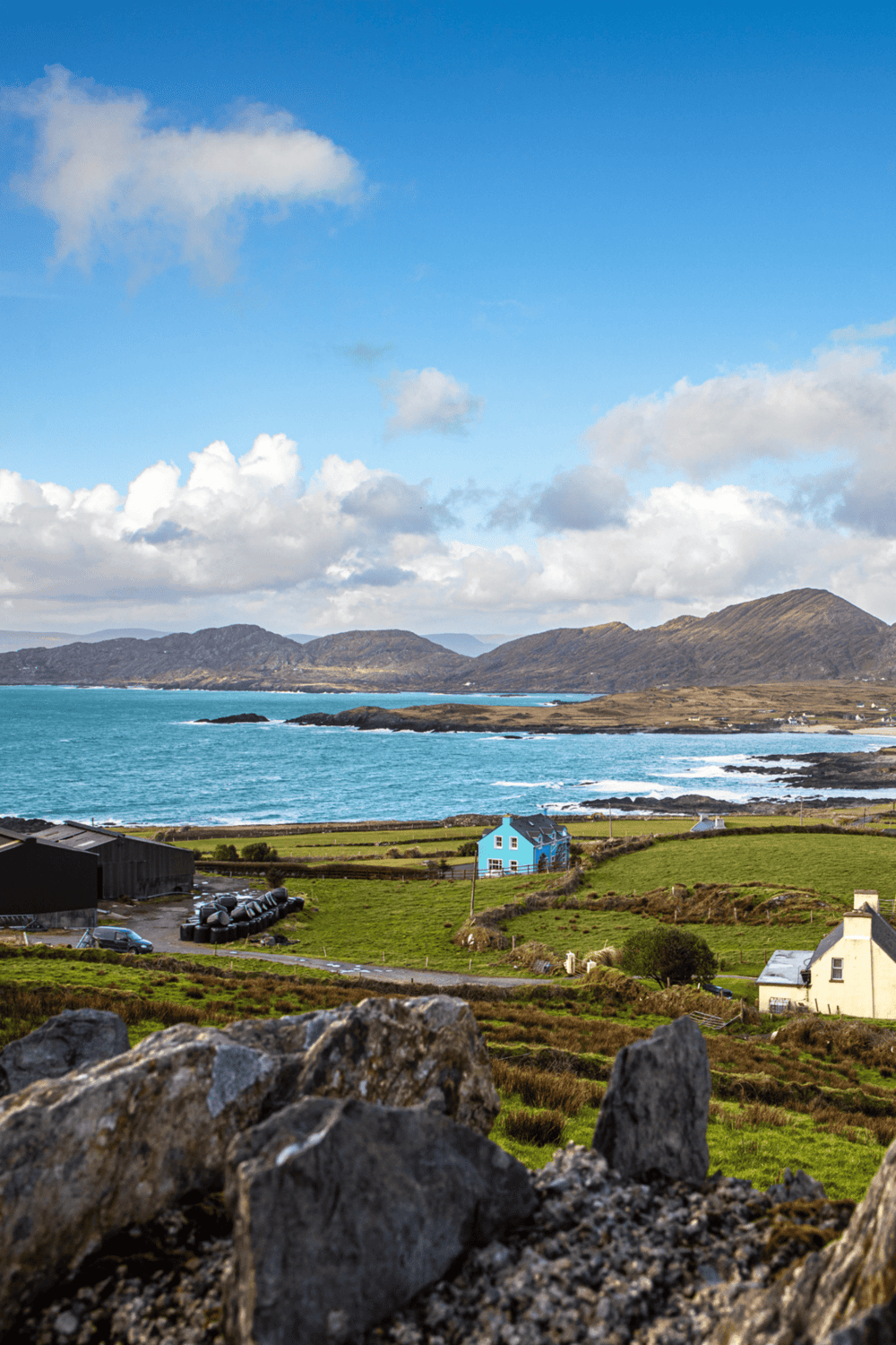 Coastal landscape with colorful houses, rolling hills, and ocean views in Ireland, perfect for scenic travel destinations.