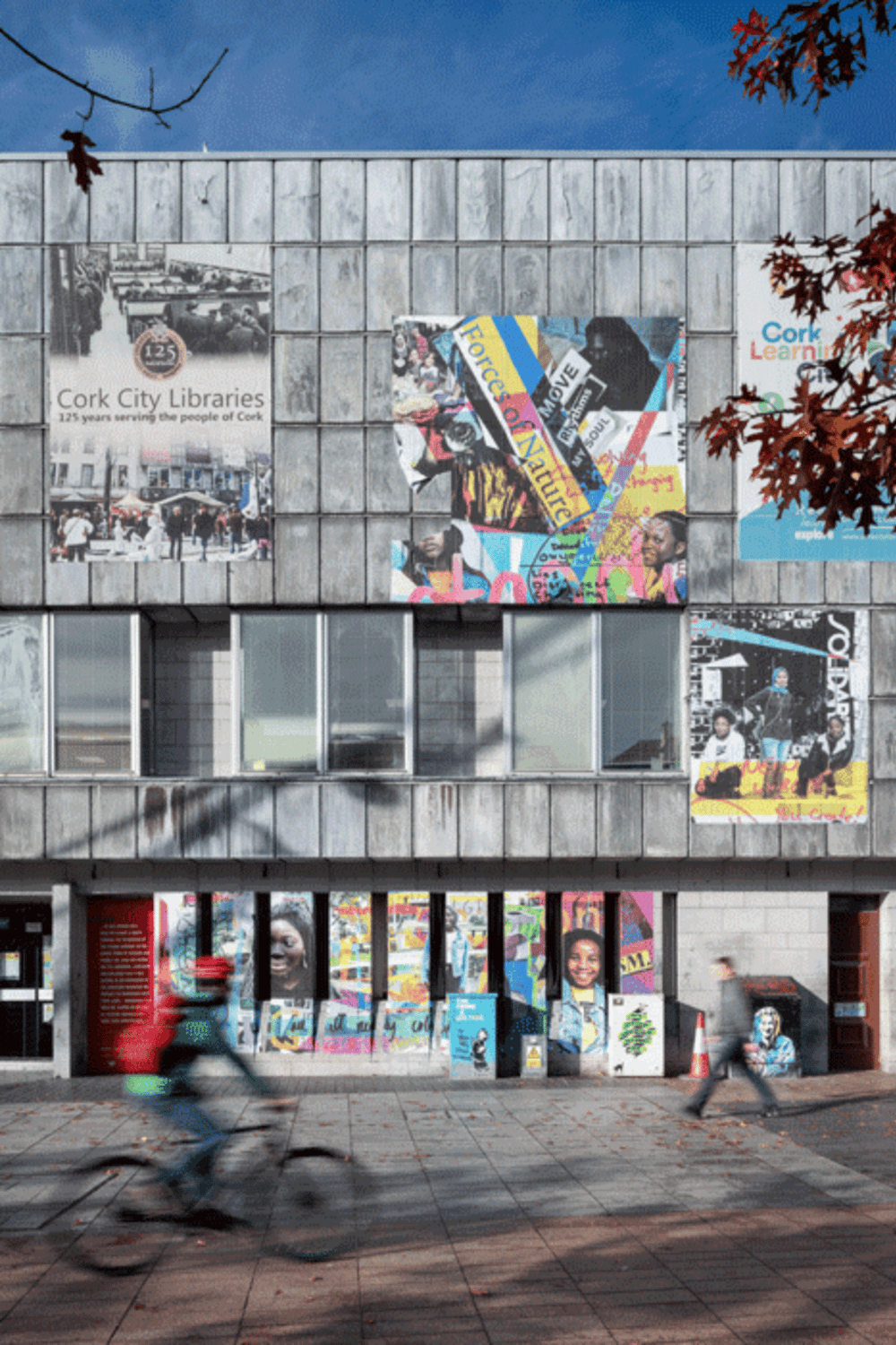 Colorful murals on Cork City Libraries building promoting community and local art.
