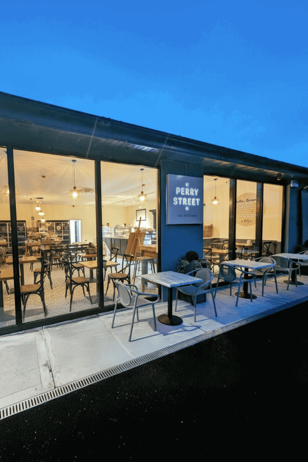 Cozy cafe interior at dusk with modern seating, inviting ambiance, and branding for Quest for Directions.