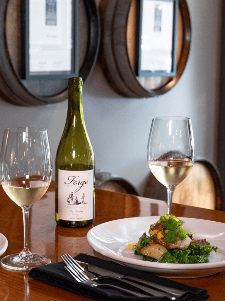 Elegant wine and gourmet dish at a fine dining restaurant with wine barrels decor.