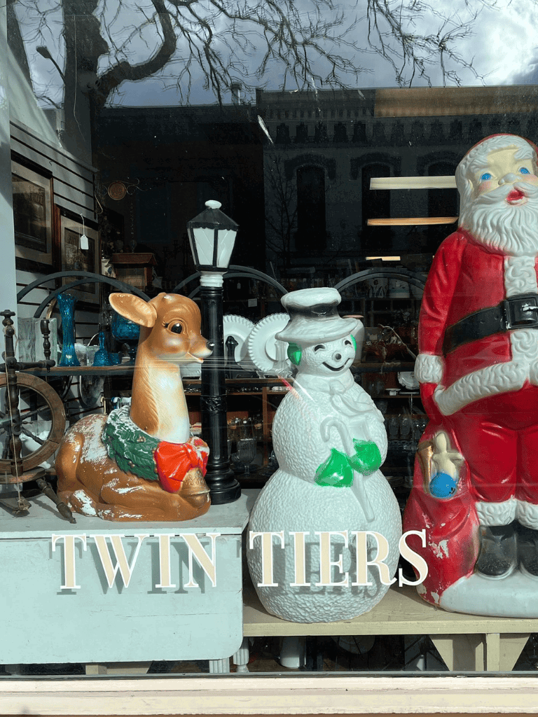 Colorful vintage holiday decorations featuring a reindeer, snowman, and Santa Claus figurine.