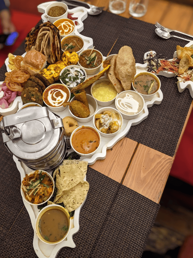 Assorted Indian vegetarian thali platter with various curries and bread for authentic cuisine.