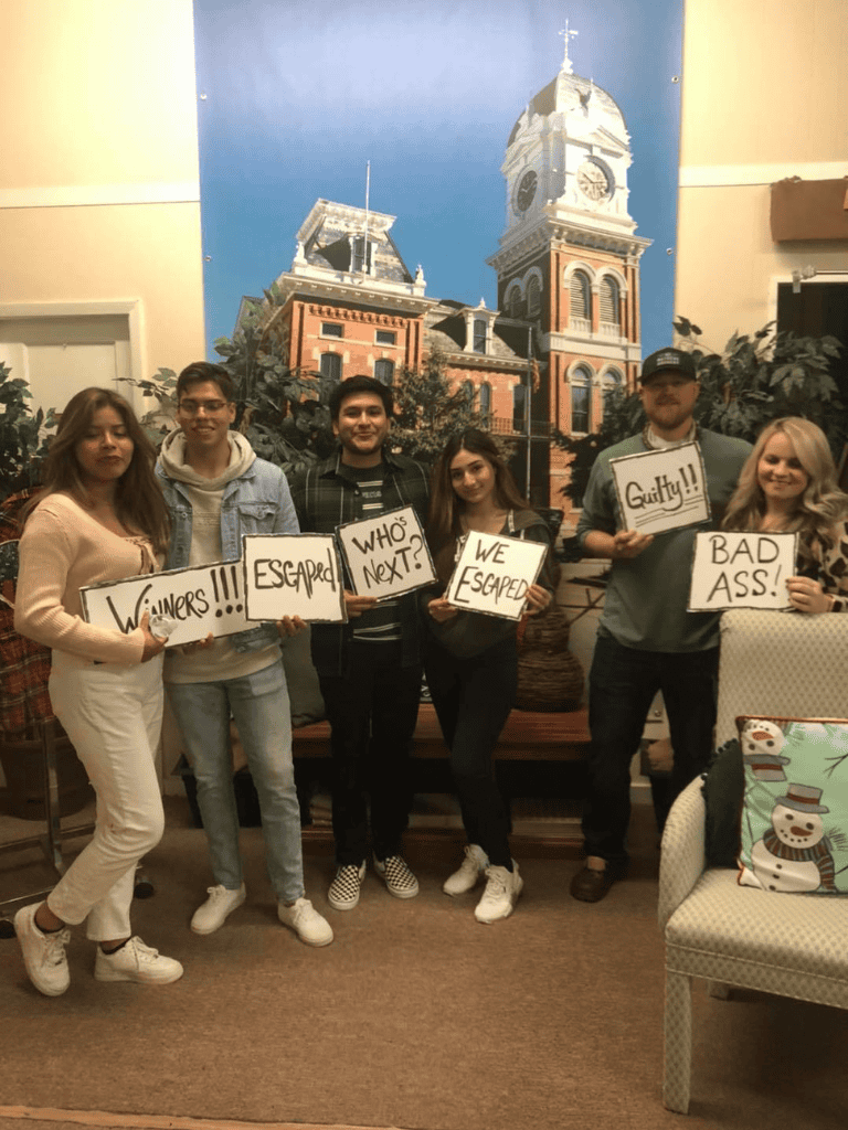Escape Room team celebrating after solving puzzles at Quest for Directions.