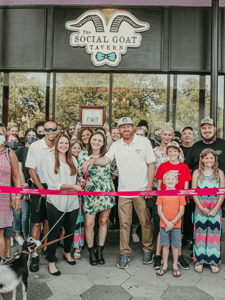 Enjoying grand opening celebration outside The Social Goat Tavern, with community members, family, and friends.