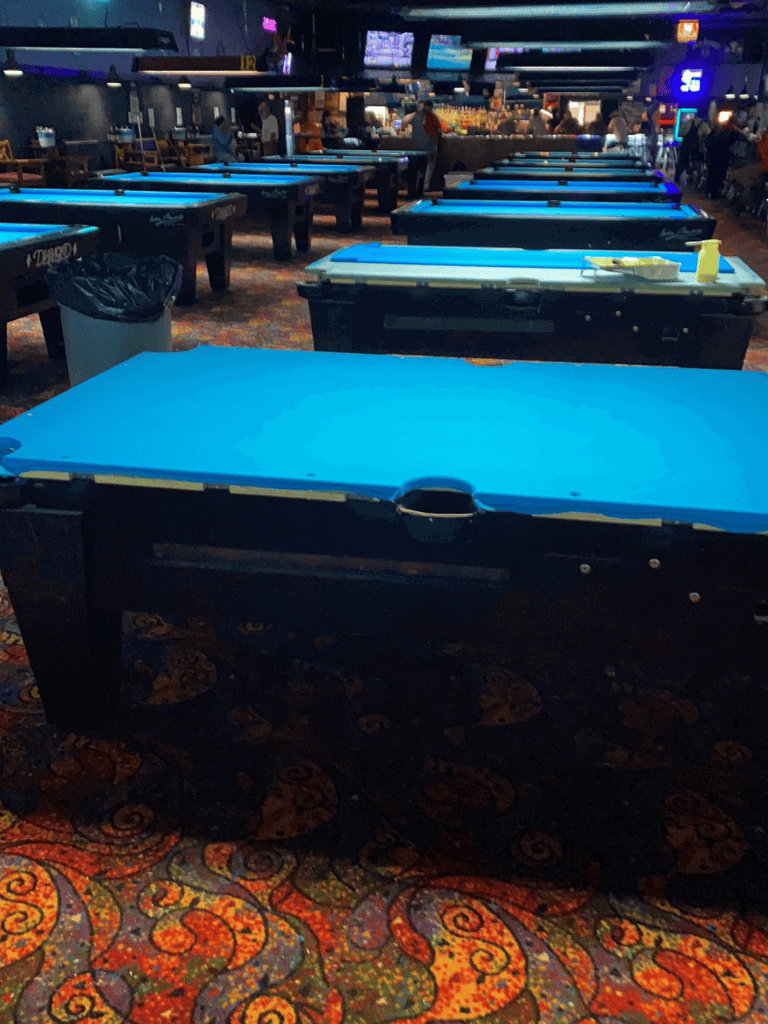 Folded pool tables prepared for billiards at QuestForDirections entertainment venue.