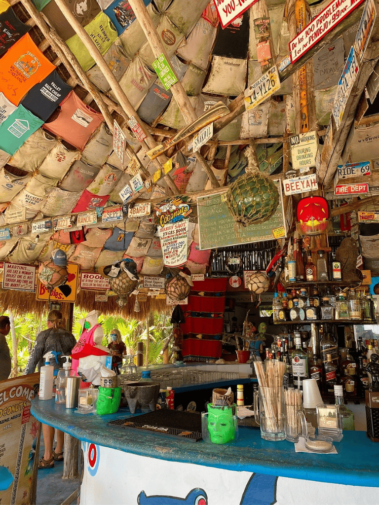 Colorful beach bar decorated with lanterns, signs, and tropical decorations, ideal for tropical vacations and beach parties.