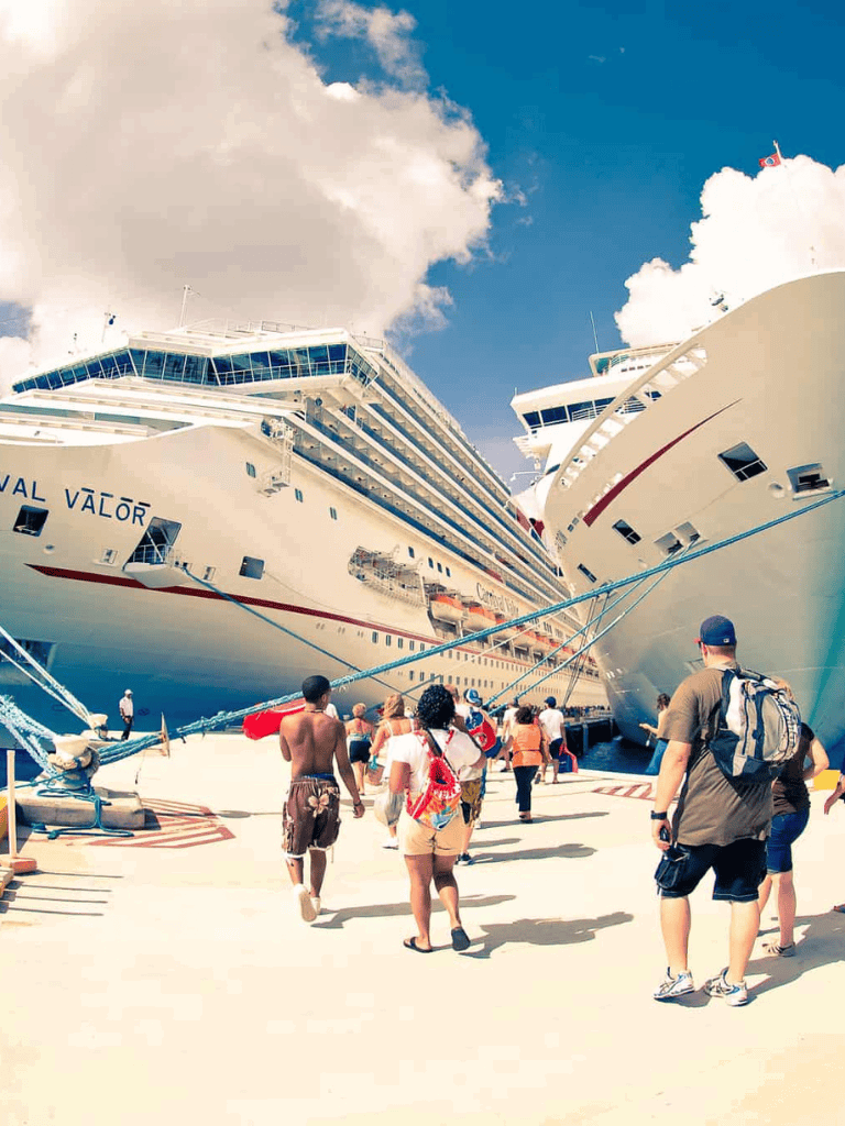 Large cruise ships docked at port with tourists embarking for vacation destinations.