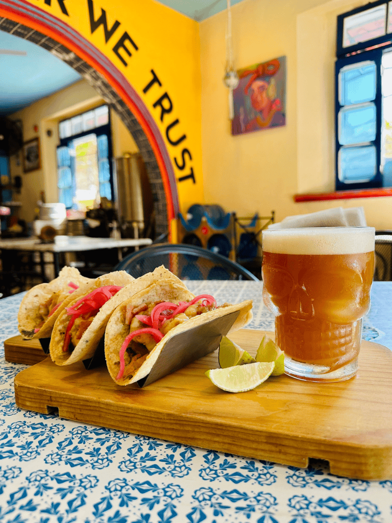 Savory tacos with lime wedges and craft beer in cozy restaurant, authentic Mexican food and drinks experience.