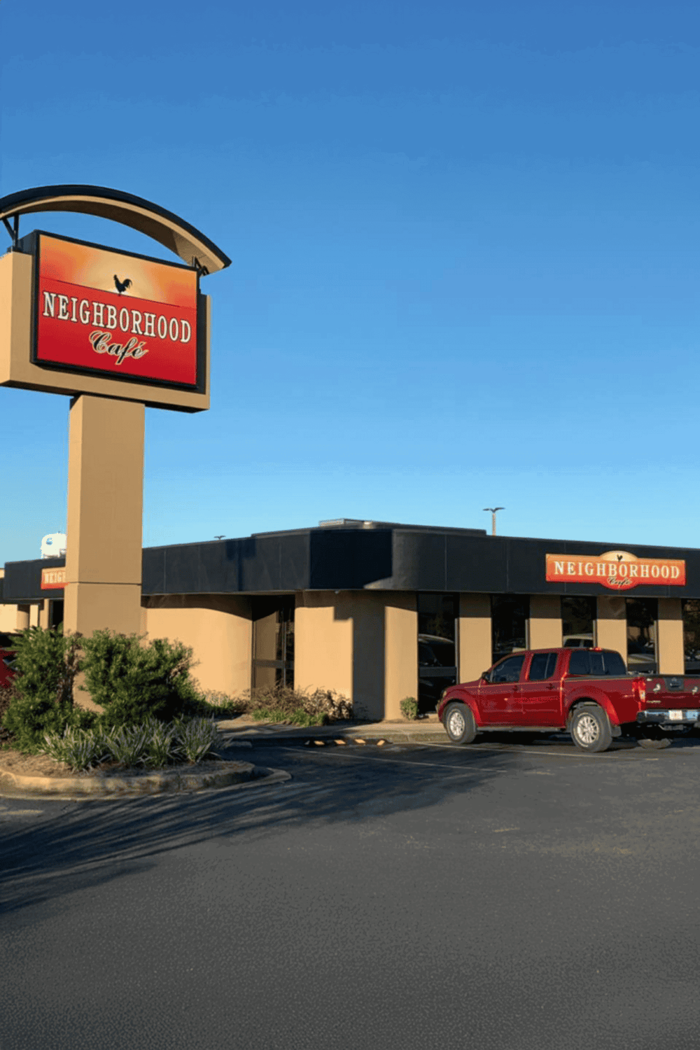 Neighborhood Cafe exterior with roadside signage, sunny day, and parking lot.