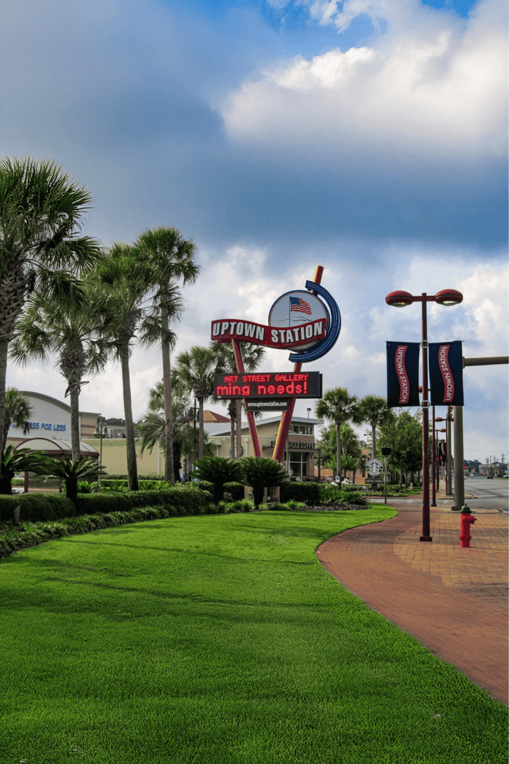 Uptown Station neon sign with palm trees and landscaped sidewalk, vibrant shopping district, and art gallery nearby.