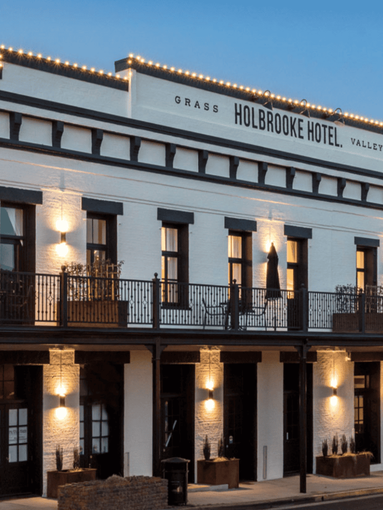Elegant historic hotel with outdoor balcony and charming lighting in a downtown area.