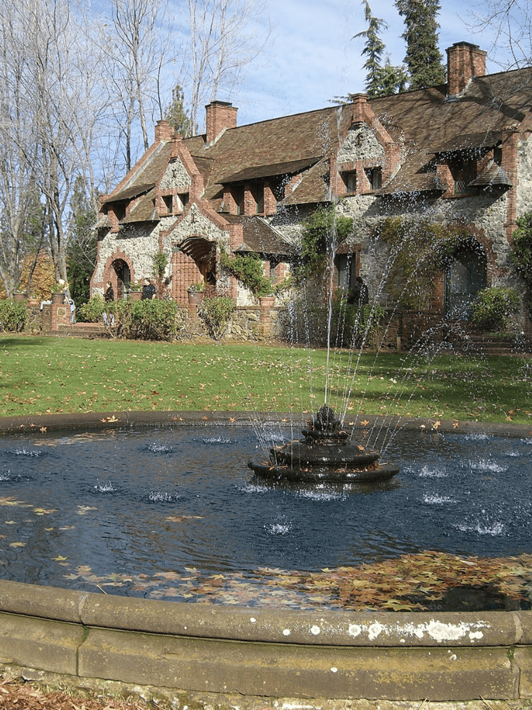 Vintage house with fountain in front, surrounded by autumn leaves and trees, at QuestForDirections.