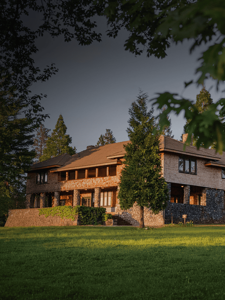 Secluded mountain home surrounded by tall trees and lush greenery, offering peaceful retreat and scenic views.