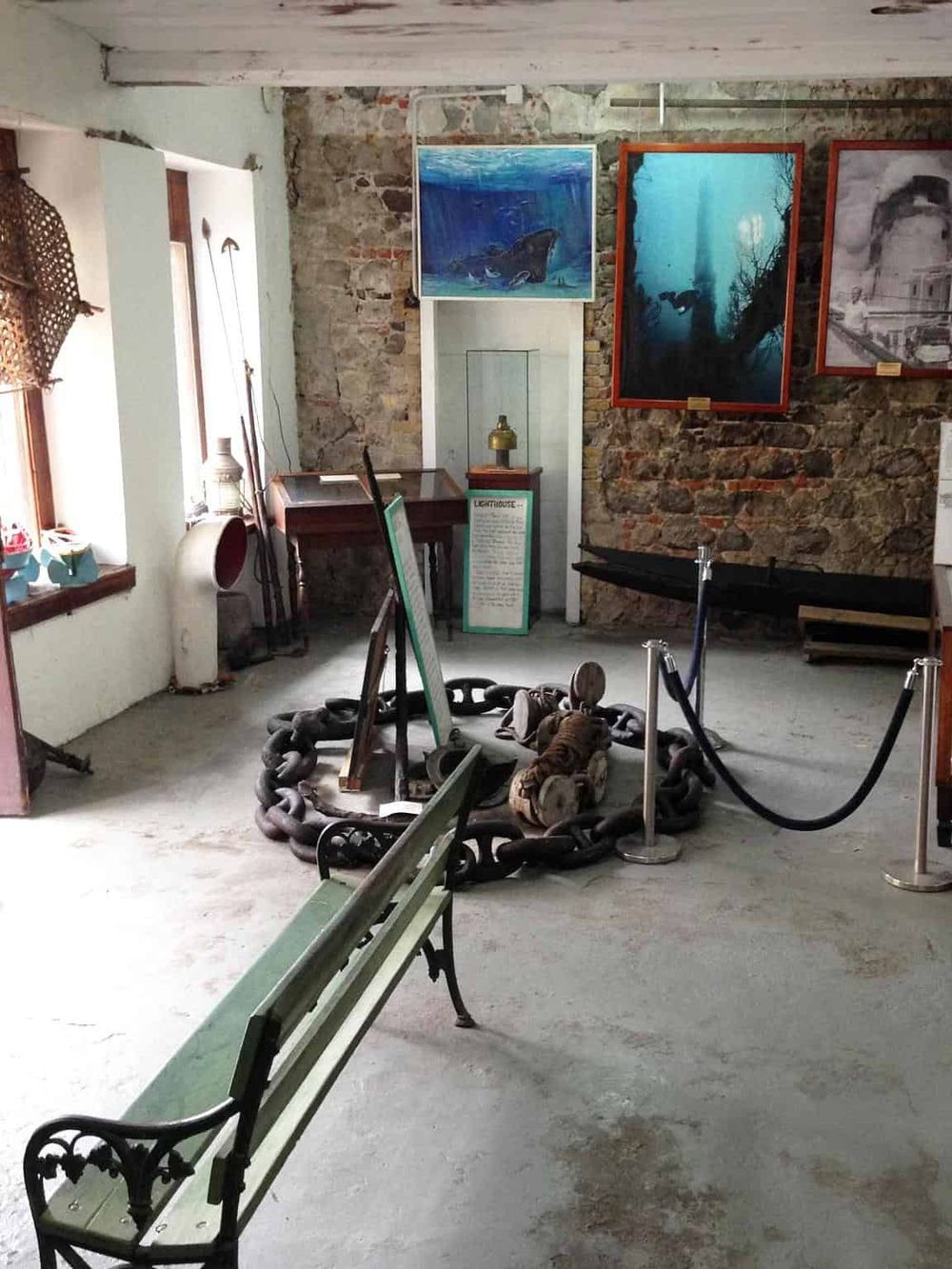 1. Antique lighthouse exhibit with vintage chain and nautical artifacts in a rustic museum display.