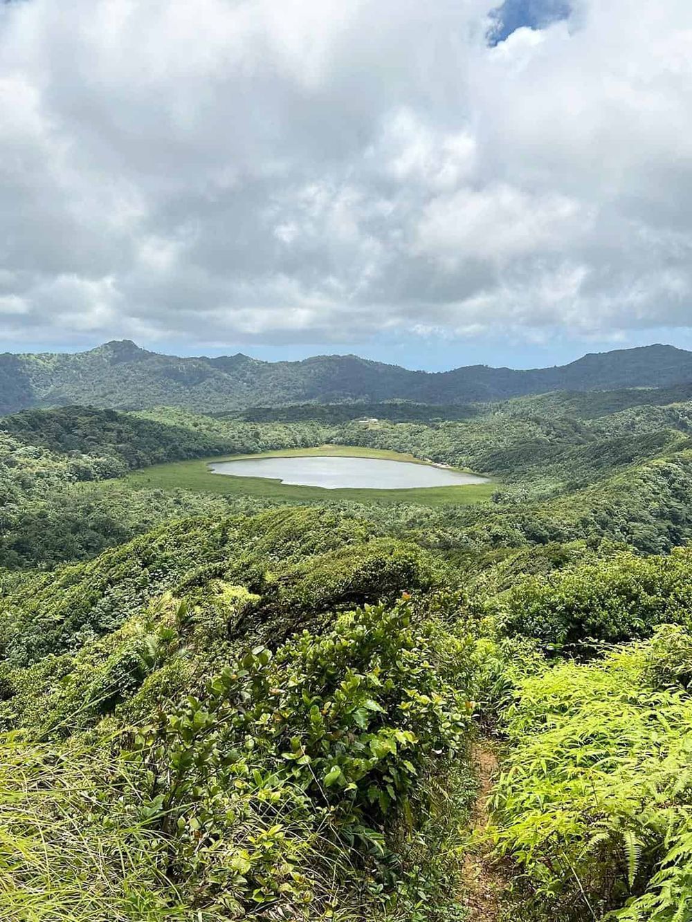 Lush green landscape with mountain lake and cloudy sky at QuestForDirections.