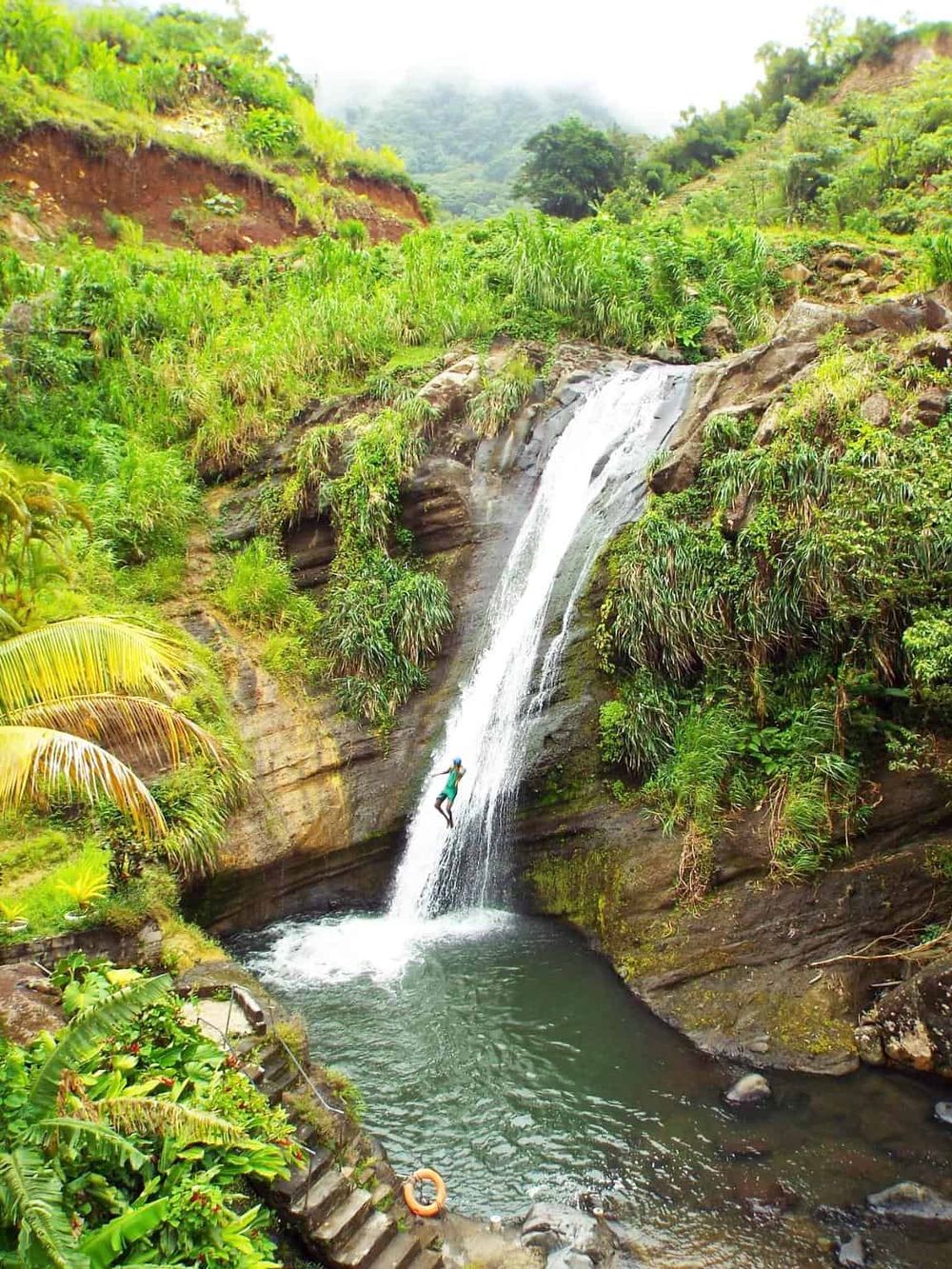 Vibrant tropical waterfall surrounded by lush greenery and cascading water, ideal for adventure and nature exploration.