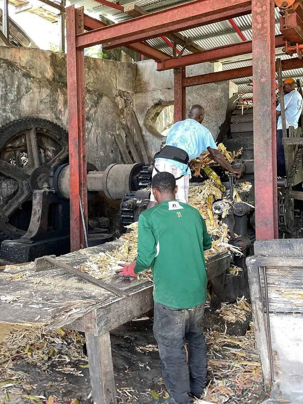 Traditional sugarcane juice extractor machine in operation at a local processing site.